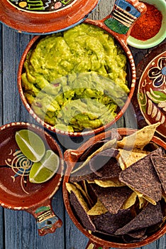 Guacamole and tortilla chips in vintage red clay pots