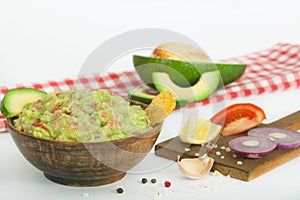 Guacamole with vegetables and snacks in a wooden bowl, vegan snack, vegetarian concept dinner.