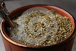 Guampa with bombilla and mate tea on table, closeup