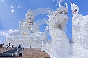 Guan Yin statue and dragon statue with blue sky and clouds sky at Huay Pla Kang Temple, Chiangrai, Thailand
