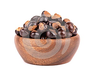 Guarana seed in wooden bowl, isolated on white background. Dietary supplement guarana, caffeine cource for energy drinks