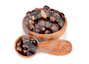 Guarana seed in wooden bowl and spoon, isolated on white background. Dietary supplement guarana, caffeine cource for