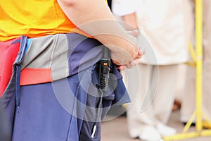 guard in civilian clothes and a walkie-talkie on his belt keeps order among the crowd of people