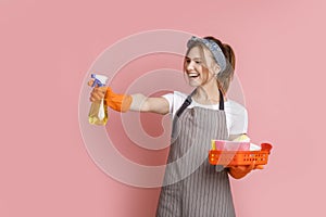 On Guard Of Cleanliness. Cherful Housemaid Playfully Aiming With Sprayer Detergent photo