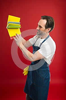 On guard of cleanliness and order. Cleaning service and household duty. Man in apron with gloves hold different sponges