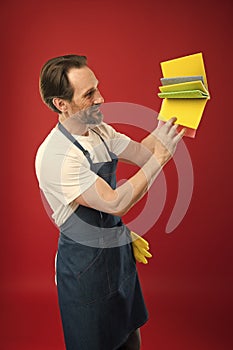 On guard of cleanliness and order. Cleaning service and household duty. Man in apron with gloves hold different sponges