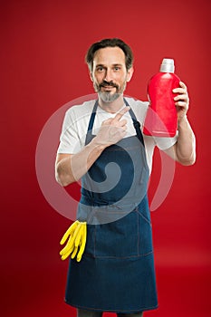 On guard of cleanliness and order. Cleaning service and household duty. Man in apron with gloves hold plastic bottle
