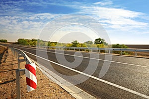 Guard rail and empty asphalt highway. Road trip