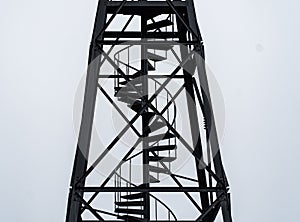 Guard tower with spiral stairs against the gloomy sky