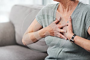 Guard your heart. a senior woman suffering from chest pain while sitting on the sofa at home.