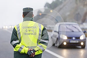 Guardia Civil officer next to a speed control monitors traffic