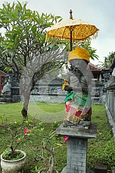 Guardian statue with umbrella at temple in Lovina Bali, Indonesia