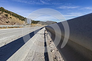 Guardrail on a tarmac road blue sky landscape