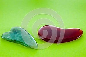 Guasha scrapers for body massage according to the ancient method shot on a bright green background