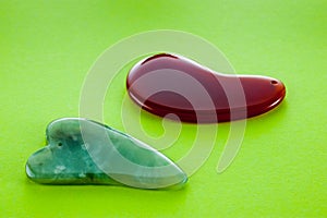 Guasha scrapers for body massage according to the ancient method shot on a bright green background