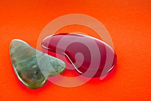 Guasha scrapers for body massage according to the ancient method shot on a bright red background