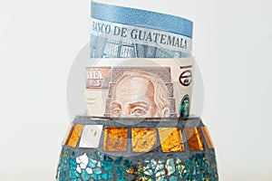 Guatemala money, quetzales banknotes sticking out from a decorative bowl, Financial concept, Financial savings, home budget