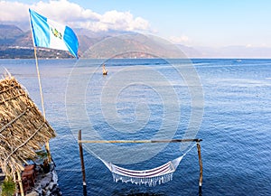 Guatemalan flag & hammock in water, San Juan la Laguna, Lake Atitlan, Guatemala