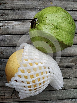 Guava fruit and pear wapped with pear net fruit on bamboo board
