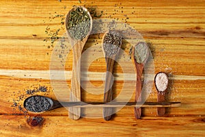 Guayacan wood background and wooden spoons with condiments