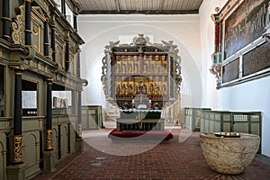 Gudow, Germany, November 13, 2020: St. Mary`s Church chancel with pews, baptismal font and the medieval carved altar in the