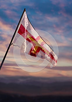 Guernsey flag, Guernesiais flag waving on sky at dusk