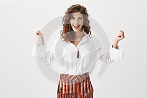 Guess who got promotion. Portrait of happy confident and pleased good-looking woman with curly brown hair, smiling