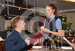 Guest in a restaurant orders meal from menu