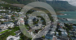 Guesthouses and residencies in suburb on seaside under majestic rocky mountain ridge. Cape Town, South Africa