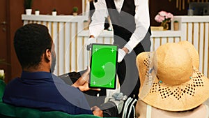 Guests holding tablet with greenscreen