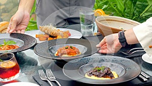 Guests at a luxury resort restaurant are served by a waiters