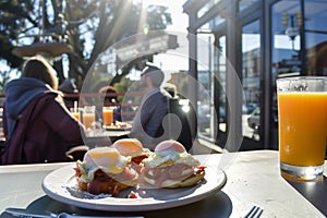 guests at sidewalk caf with eggs benedict, orange juice