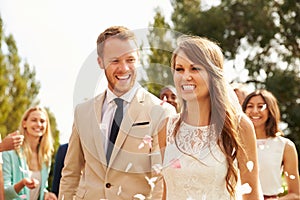 Guests Throwing Confetti Over Bride And Groom At Wedding