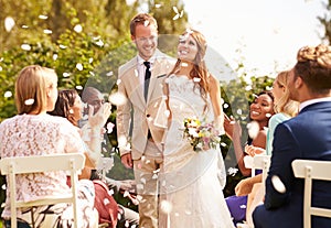 Guests Throwing Confetti Over Bride And Groom At Wedding