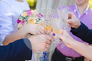 Guests at a wedding with the bride and groom clink glasses of champagne