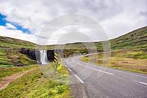 Gufufoss waterfall and car driving on highway in Fjord on summer at Iceland