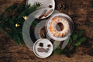 Guglhupf austrian cake with anise and cinnamon in a white plate with wood background. New year and christmas concept