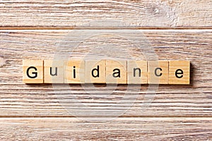 Guidance word written on wood block. Guidance text on table, concept