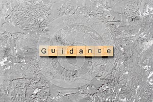 Guidance word written on wood block. Guidance text on table, concept