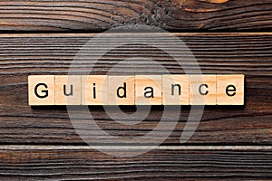 Guidance word written on wood block. Guidance text on table, concept