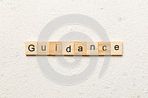 Guidance word written on wood block. Guidance text on table, concept