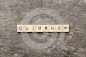 Guidance word written on wood block. Guidance text on table, concept