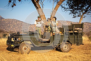 Guide and brunettes under tree in jeep