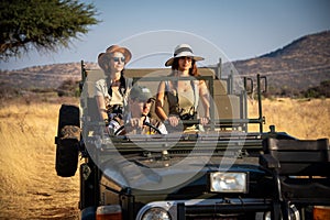 Guide drives two female guests in grassland