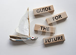 Guide for the future symbol. Wooden blocks with words Guide for the future. Beautiful white background with boat. Business and