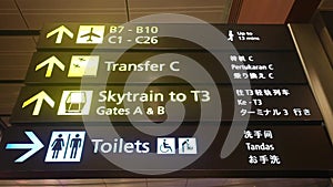 Guide sign showing way to different gates at airport. Airport display with illuminated signs and arrows to point the way