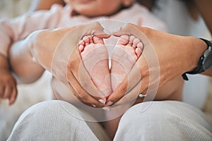 Guiding with love. an unrecognizable womans hands making a heart shape around her newborn babys feet at home.