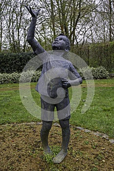 GUILDFORD, UNITED KINGDOM - Apr 04, 2018: Boy sculpture by Christine Charlesworth in the Summer Garden at Guildford Cathedr