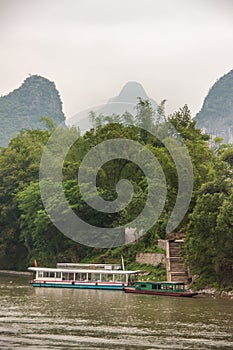 Ferry and transport boat docked at stairs along Li River in Guilin, China