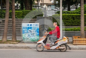 Man rides Olong scooter, Guilin, China